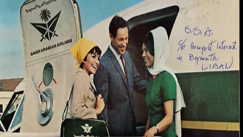 شاهد.. بطاقة بريدية تحمل إعلان الخطوط السعودية وصورة مضيفة بالزي الأخضر والوشاح الأبيض