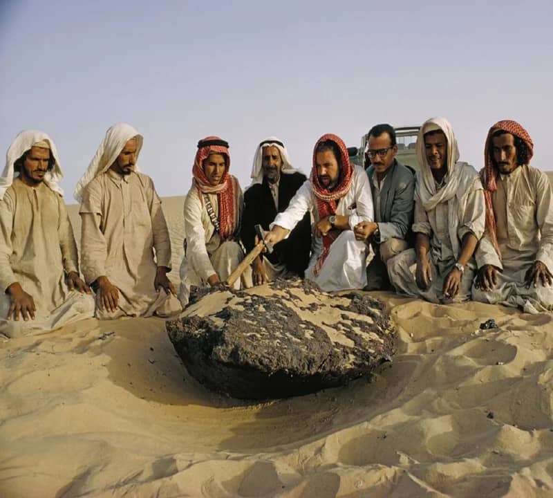 صورة لأشخاص يجلسون حول نيزك حديدي قبل 55 عام