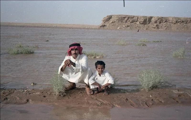 طفل وأبيه وسط جريان وادي الرمة بالقصيم قبل 40 عام