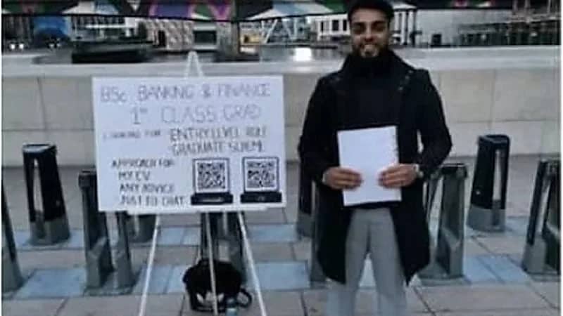 شاب يعرض سيرته الذاتية على المارة في الشوارع للحصول على وظيفة