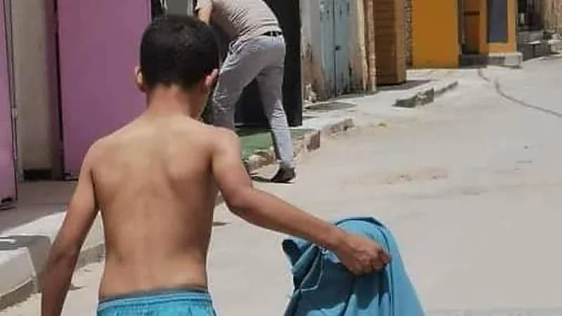 شاهد.. طفل يخلع قميصه لحماية شقيقه الأصغر من أشعة الشمس الحارقة