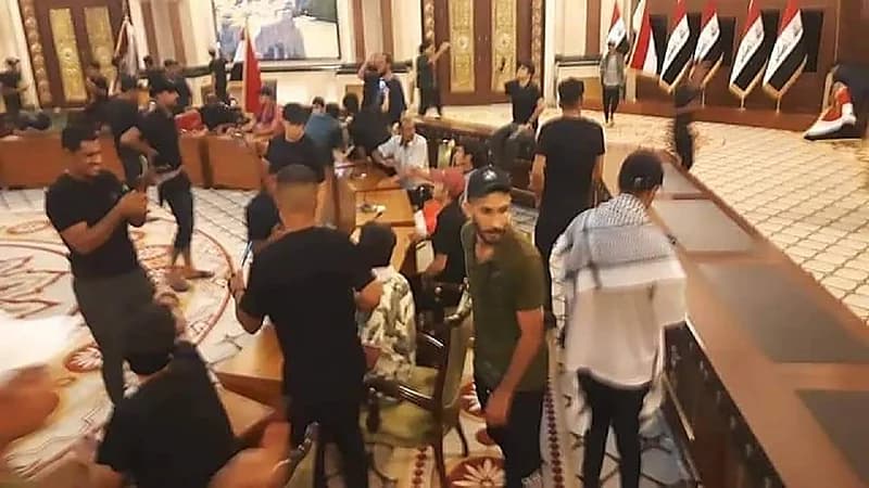 شاهد.. متظاهرون يقتحمون غرفة نوم الرئيس العراقي ويستولون على بدلته