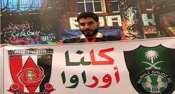 مشجع أهلاوي يحمل لافتة " كلنا أوراوا "