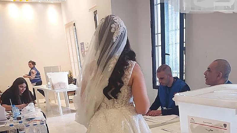 عروس بفستان الزفاف تدلي بصوتها داخل مركز اقتراع